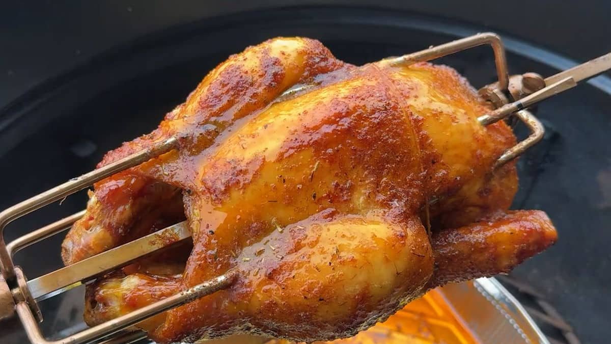Pollo al girarrosto succoso e dorato che cuoce lentamente sul barbecue