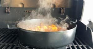 Irish Stew al barbecue nel dutch oven, pentola in ghisa su griglia