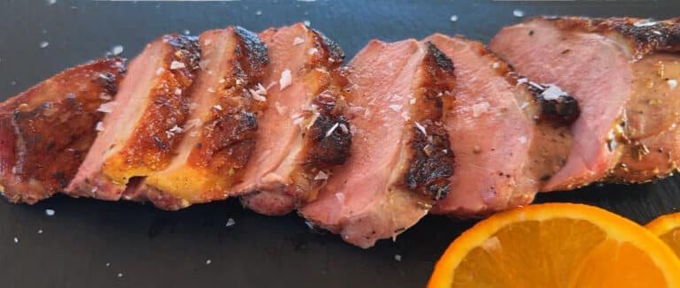 Primo piano del petto d'anatra alla griglia, fette succose e pelle croccante