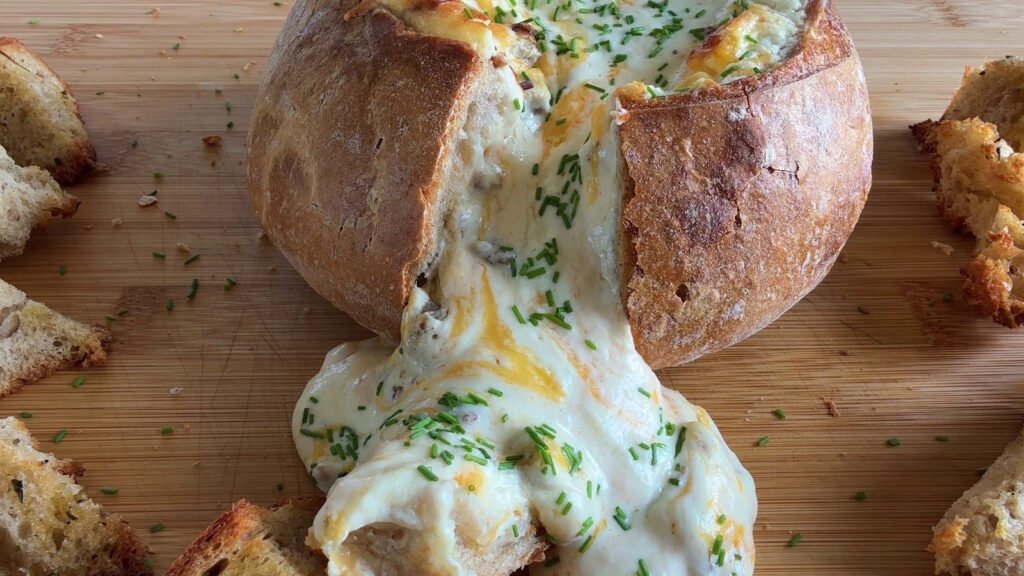 Pagnotta ripiena bbq con salsiccia e formaggio filante, servita come antipasto scenografico.