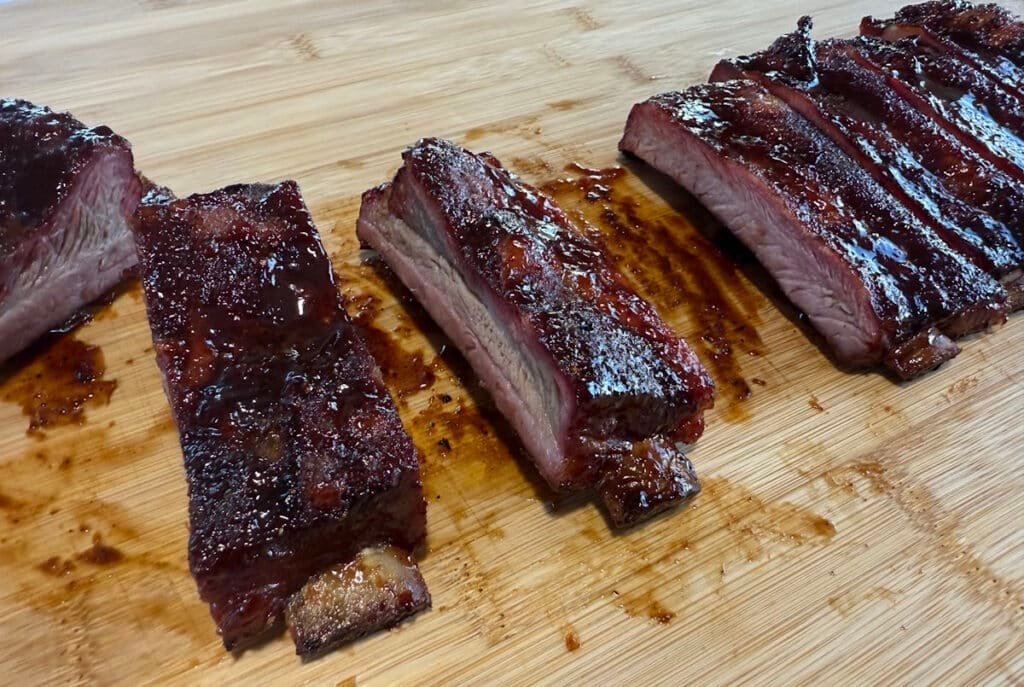 Costine di maiale su tagliere affumicate e glassate in stile Kansas City