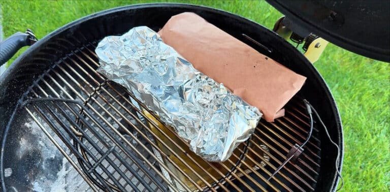 Confronto diretto in griglia tra un cartoccio di Butcher Paper rosa e uno di alluminio (Foil) per valutare la differenza sul bark durante il Texas Crutch.